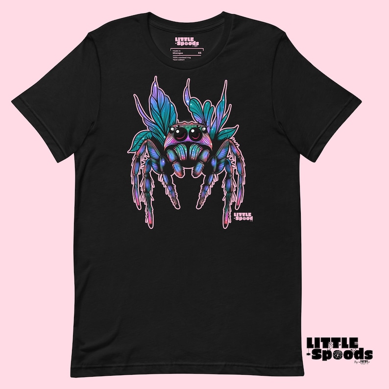 May include: Black t-shirt with a colorful jumping spider graphic. The spider has blue, purple, and green accents and is surrounded by pink and green leaves. The text "LITTLE SPOODS" is printed on the shirt.