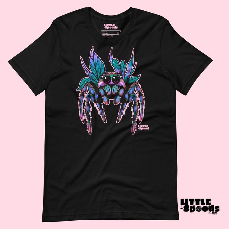 May include: Black t-shirt with a colorful illustration of a jumping spider with pink, blue, and green accents. The spider is surrounded by leaves and the text "Little Spoods" is printed on the shirt.