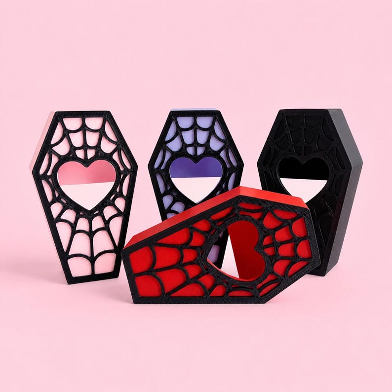 Multiple color options of the magnetic jumping spider coffin hide displayed together on a pastel pink background.