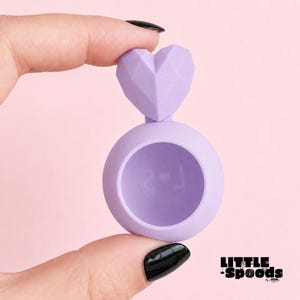 Purple heart magnetic jumping spider hide for adult regal jumping spiders shown in hand for scale in pastel pink background
