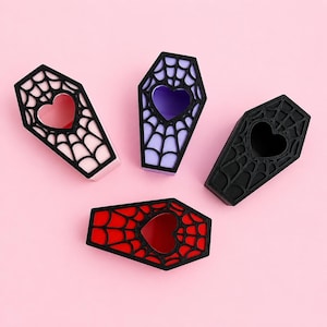Magnetic jumping spider coffin hides available in pink, purple, black, and red color options.