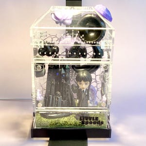 Wednesday Addams themed jumping spider enclosure glowing under optional Lumi light.