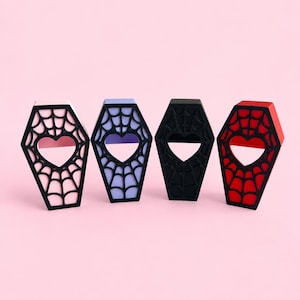 Pink, purple, black, and red magnetic jumping spider coffin hides displayed side by side.