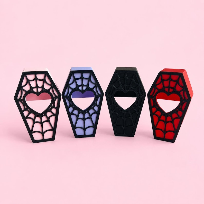 Pink, purple, black, and red magnetic jumping spider coffin hides displayed side by side.