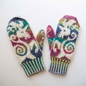 May include: A pair of colorful knitted mittens with a white background and a swirling pattern. The mittens have a green, blue, pink, and purple color scheme.