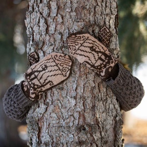 May include: A pair of brown and beige knitted mittens with intricate patterns are wrapped around a tree trunk.