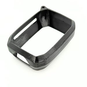 Könnte beinhalten: Ein schwarzes, rechteckiges 3D-gedrucktes Objekt mit hohler Mitte und abgerundeten Kanten. Das Objekt hat eine strukturierte Oberfläche mit sichtbaren Schichtlinien und eine kleine Schlaufe oben. Das Design deutet auf eine Schutzhülle oder einen Rahmen hin.