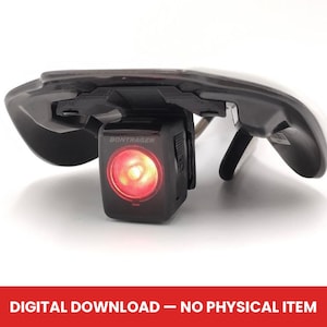 Puede incluir: Una luz trasera de bicicleta Bontrager negra montada en un sillín de bicicleta negro. La luz trasera tiene una luz roja brillante. El texto "DIGITAL DOWNLOAD - NO PHYSICAL ITEM" está en la parte inferior de la imagen.