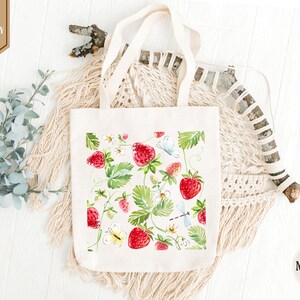 a white bag with strawberries and flowers on it