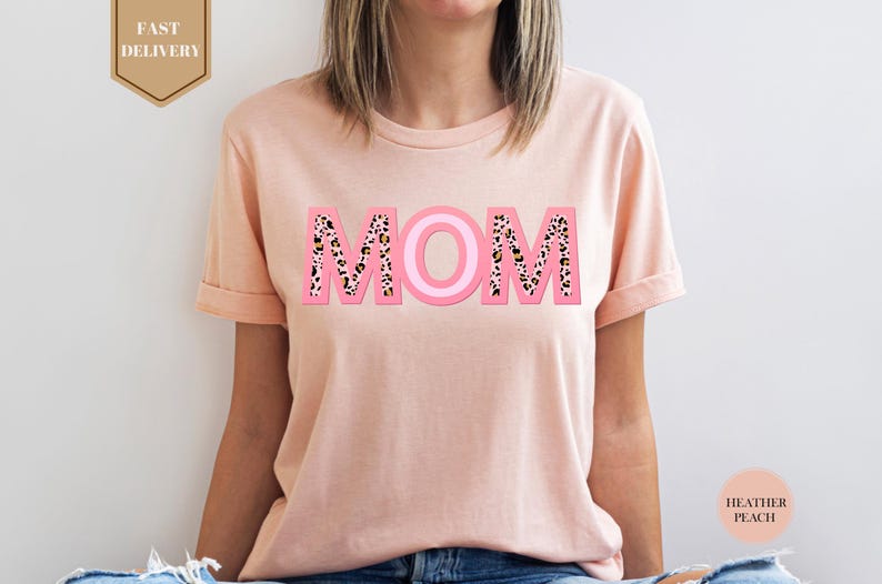 a woman wearing a pink mom shirt with leopard print