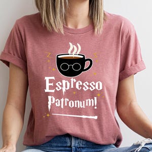 a woman wearing a pink shirt that says espresso patronum