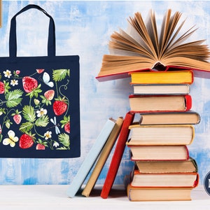 a stack of books and a tote bag next to a stack of books