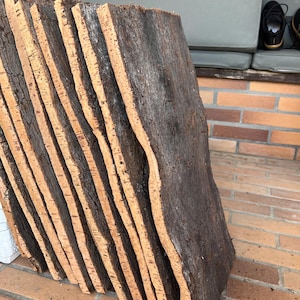 Peut inclure: Une pile de fines feuilles de liège rectangulaires de couleur brun naturel et à la surface rugueuse et texturée. Les feuilles sont empilées les unes sur les autres, créant un effet de superposition.