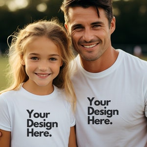 May include: A father and daughter wearing white t-shirts with the text "Your Design Here." printed on them. They are smiling and looking at the camera.