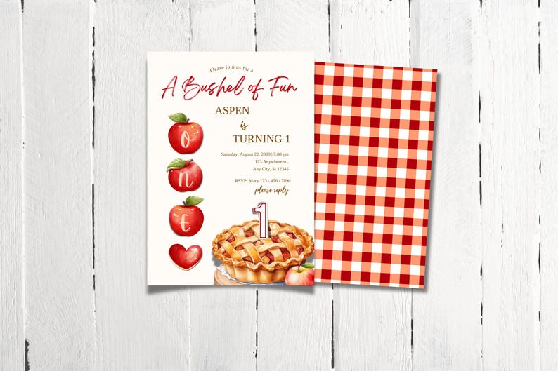 K&ouml;nnte beinhalten: Ein rot-wei&szlig; karierter Hintergrund mit einer wei&szlig;en Einladungskarte. Die Einladungskarte hat ein rotes Apfel-Motiv und lautet "A Bushel of Fun Aspen is Turning 1" mit einem Kuchen und einer Kerze.