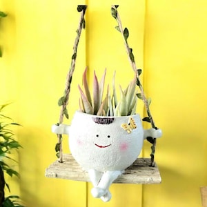 Huśtająca się doniczka z uśmiechniętą buzią: sztuczne sukulenty, fantazyjny wystrój domu