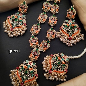 May include: A gold necklace and earrings set with intricate floral designs and colorful stones. The necklace has a long, dangling design with multiple layers of beads and pearls. The earrings are similarly ornate with a dangling design and pearls.