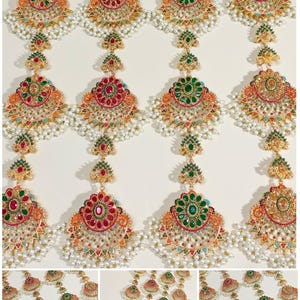 Puede incluir: Pendientes dorados ornamentados con diseños intrincados. Cada pendiente presenta una piedra preciosa central, rodeada de gemas más pequeñas en rojo, verde y naranja. Perlas blancas y delicados detalles dorados completan el look. Disposición vertical.