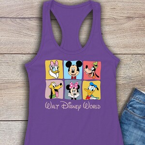 Puede incluir: Camiseta de tirantes morada con un gr&aacute;fico colorido de Mickey Mouse, Minnie Mouse, Donald Duck, Goofy, Pluto y Daisy Duck. El gr&aacute;fico est&aacute; en un patr&oacute;n de cuadr&iacute;cula con cada personaje en un cuadrado separado. El texto "WALT DISNEY WORLD" est&aacute; debajo del gr&aacute;fico.