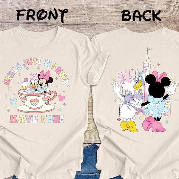 Könnte beinhalten: Zwei weiße T-Shirts mit einem pinkfarbenen, blauen und gelben Grafikdesign. Das vordere Shirt sagt "Girls Just Wanna Have Fun!" mit einem Cartoon-Bild von Minnie Mouse und Daisy Duck. Das hintere Shirt hat ein Cartoon-Bild von Minnie Mouse und Daisy Duck vor einem rosa Schloss.
