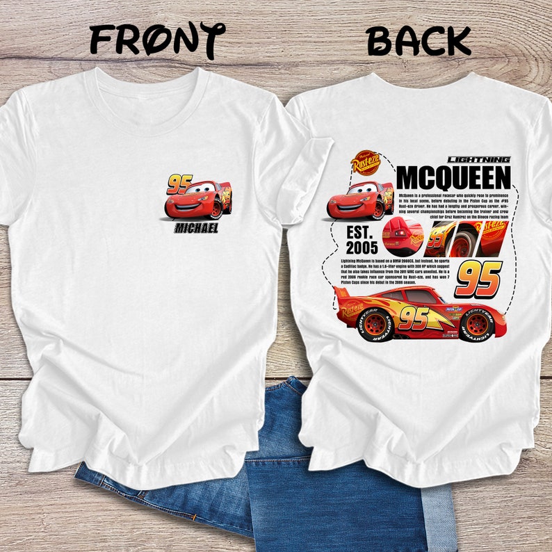 Op de afbeelding: Wit T-shirt met een rode racewagen afbeelding op de voorkant en een grotere rode racewagen afbeelding met tekst op de achterkant. De tekst op de achterkant luidt "Lightning McQueen, Est. 2005".