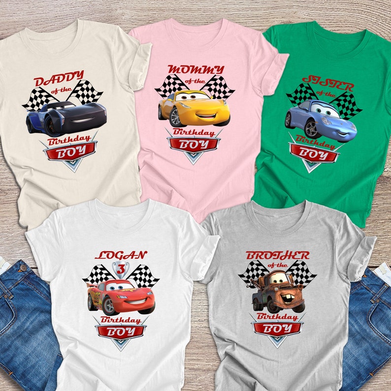 May include: Five white t-shirts featuring different Cars characters and text. The shirts read "Daddy of the Birthday Boy", "Mommy of the Birthday Boy", "Brother of the Birthday Boy", "Sister of the Birthday Boy", and "Logan 3 Birthday Boy".