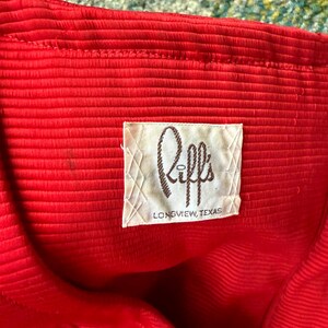 May include: A red ribbed fabric with a white label that says "Riff's Longview, Texas".