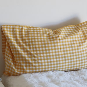 May include: A rectangular pillow with a yellow and white gingham pattern. The pillow is resting on a white, fluffy surface. The image includes the text "&copy; Pegycrafts ALL RIGHTS RESERVED".