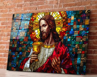 May include: A stained glass depiction of Jesus Christ holding a chalice. The image is made up of colourful glass pieces in shades of red, blue, yellow, and green.