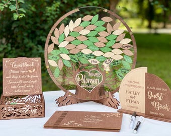 Puede incluir: Un juego de libro de visitas de boda de madera. Incluye un tablero de registro en forma de árbol con recortes de hojas, un libro de visitas y una caja decorativa. El árbol tiene un corazón con los nombres "MR&MRS Peterson" y la fecha "08.09.2025".