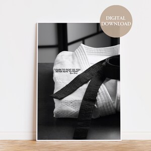 May include: Black and white photo of a white karate uniform with a black belt tied around it. The quote "Learn to fight so you never have to fight" is printed on the uniform.