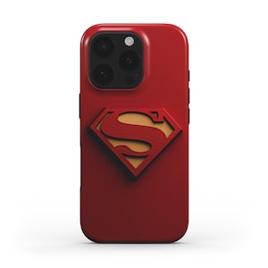 Könnte beinhalten: Eine rote Smartphone-Hülle mit einem erhabenen, dreidimensionalen Superman-Logo in der Mitte. Das ikonische Emblem besteht aus einem roten Buchstaben S auf einem goldfarbenen rautenförmigen Hintergrund. Die Hülle hat eine Aussparung für die Kamera.