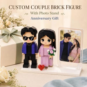 Puede incluir: Figura de pareja personalizada de bloques con soporte para fotos y texto de regalo de aniversario. Dos figuras de estilo bloque, una con chaqueta azul y gafas de sol, la otra con traje lavanda y flores, sobre una base blanca junto a un marco acrílico.