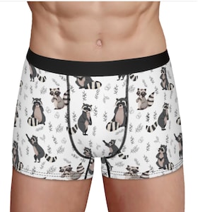 May include: White boxer shorts with a black waistband and a repeating pattern of raccoons and leaves.