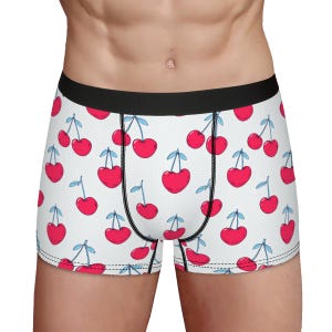 May include: White boxer shorts with a repeating pattern of red cherries on a white background.