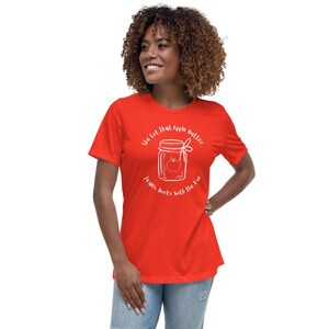 May include: A red t-shirt with a white graphic of a jar of apple butter with the text "She got that apple butter, jeans, beets with the flow".