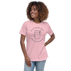 May include: A pink t-shirt with the text "She got that apple butter, jeans, boots with the fur" and a drawing of a jar of apple butter.