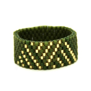 Peut inclure: Une bague en perles vertes et dorées avec un motif géométrique.