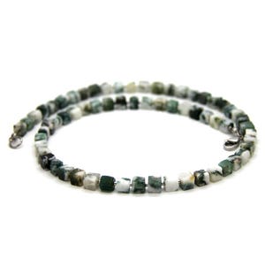 Puede incluir: Un collar de piedras de ágata verde y blanca con cuentas cuadradas. El collar está hecho con cierres de plata.