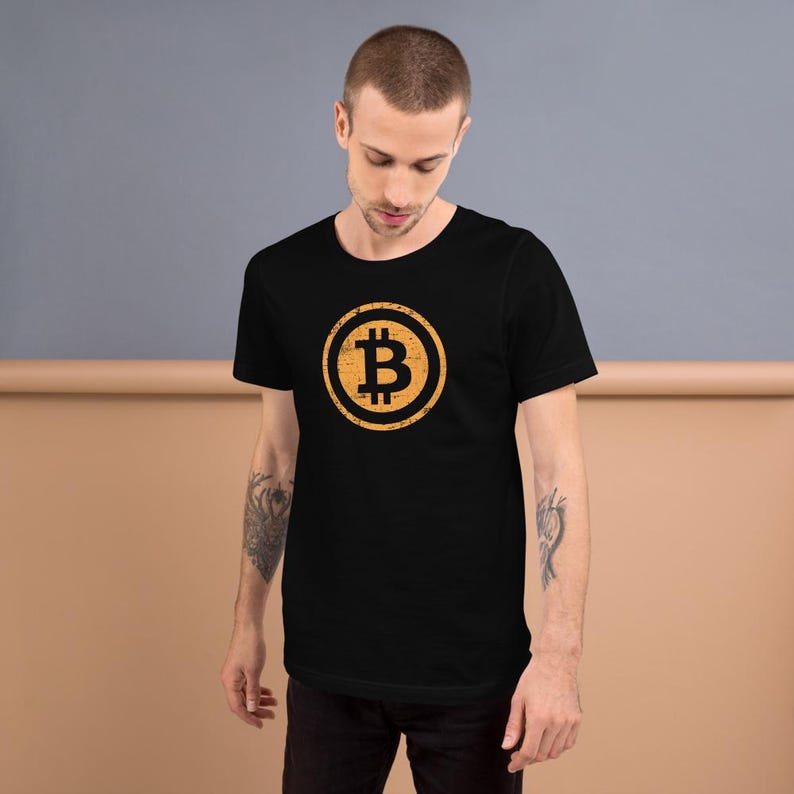 May include: Black t-shirt featuring a distressed, circular Bitcoin symbol in shades of yellow and orange. The Bitcoin logo is centered on the chest. The shirt is made of a soft material and has short sleeves.