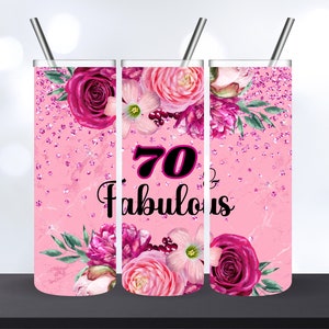 Op de afbeelding: Een roze beker met een bloemenpatroon en de tekst "70 & Fabulous".