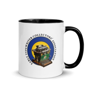 May include: White ceramic mug with a black rim and handle. The mug features a circular logo with the text "Early Typewriter Collectors' Association" in black text on a blue background with a yellow circle and a vintage typewriter image.