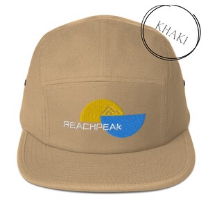 Może przedstawiać: Czapka 5-panelowa w kolorze khaki z haftowanym logo w kolorze niebieskim i żółtym z napisem "REACHPEAK"