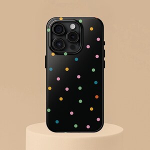 May include: Black phone case with a colourful polka dot pattern.