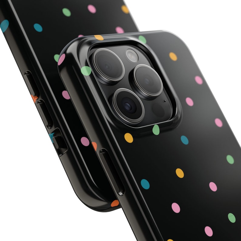 May include: A black phone case with a colourful polka dot pattern. The case has a raised camera bump with three lenses.