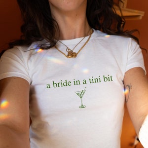 A Bride In A Tini Bit Baby Tee Dirty Martini Themed Bachelorette Party Dirty Martini Bride Baby Tee Dirty Martini Bachelorette Martini Bach