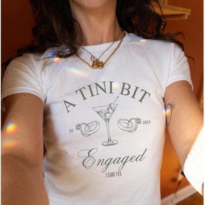 Tini Bit Engaged Baby Tee Dirty Martini Bachelorette Engagement Shirt Engagement Gift Fiancee Shirt Martini Theme Bride In A Tini Bit TShirt