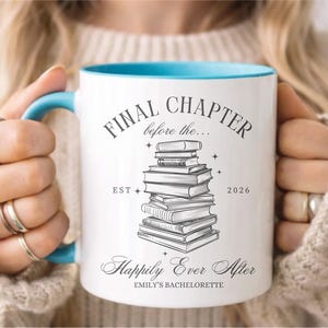 May include: White ceramic mug with a blue interior and handle. The mug features the text "FINAL CHAPTER before the..." above a stack of books, with "Happily Ever After" below. The year "2026" is also printed on the mug.