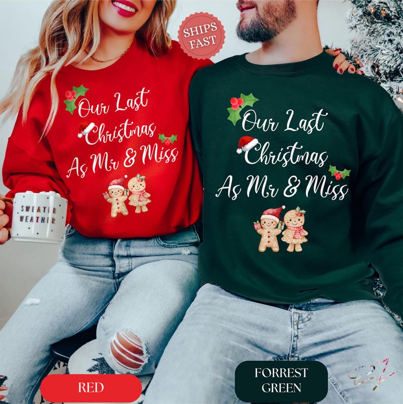 Op de afbeelding: Een rood sweatshirt en een donkergroen sweatshirt, elk met de tekst Our Last Christmas As Mr & Miss, versierd met hulst, een kerstmuts en twee peperkoekmannetjes. Het rode shirt wordt gedragen met een blauwe spijkerbroek, het groene shirt ook.