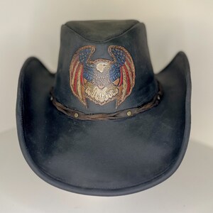 May include: A black leather cowboy hat with a brown leather band and a red, white and blue eagle design.